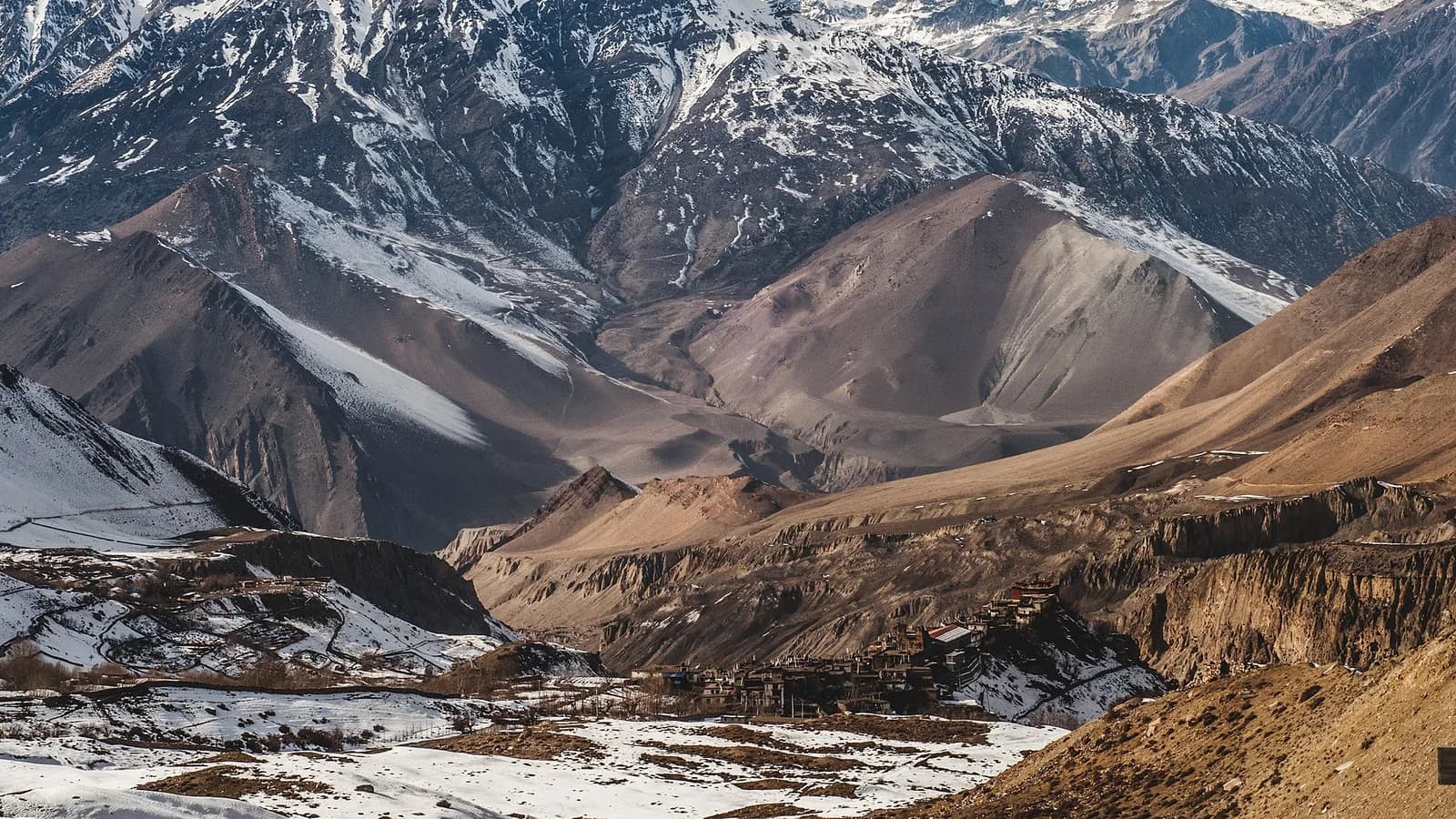 Panorama of the snow-capped Annapurna massif rising above forested foothills in Nepal