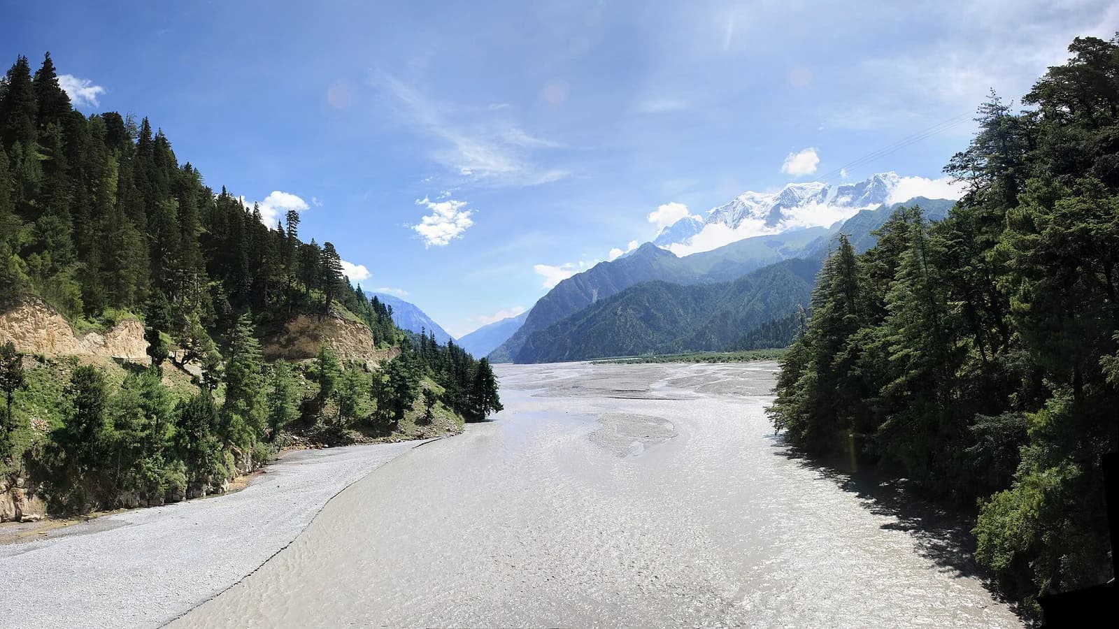 The Kali Gandaki River running through a forested Himalayan gorge with snow peaks beyond