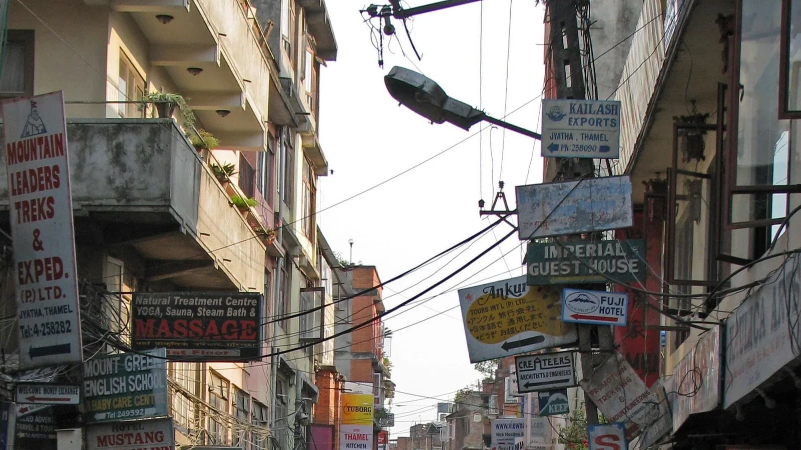 Busy street in Thamel, Kathmandu, lined with shop signs written in Devanagari script and English