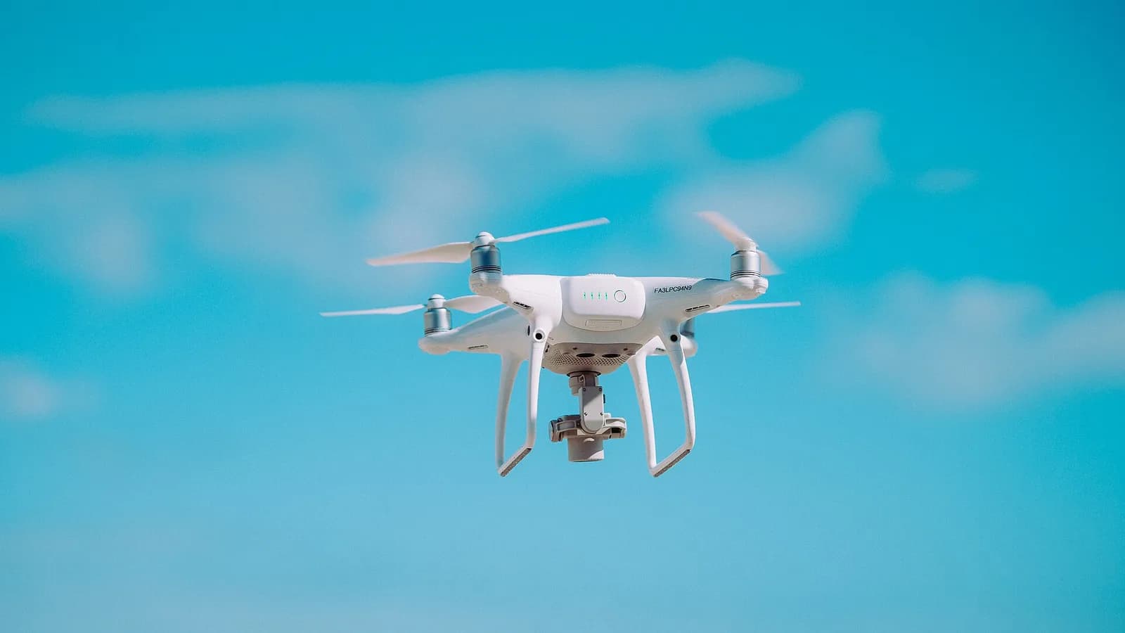 A camera drone in flight against an open sky, the kind of quadcopter regulated under Nepal's CAAN drone rules
