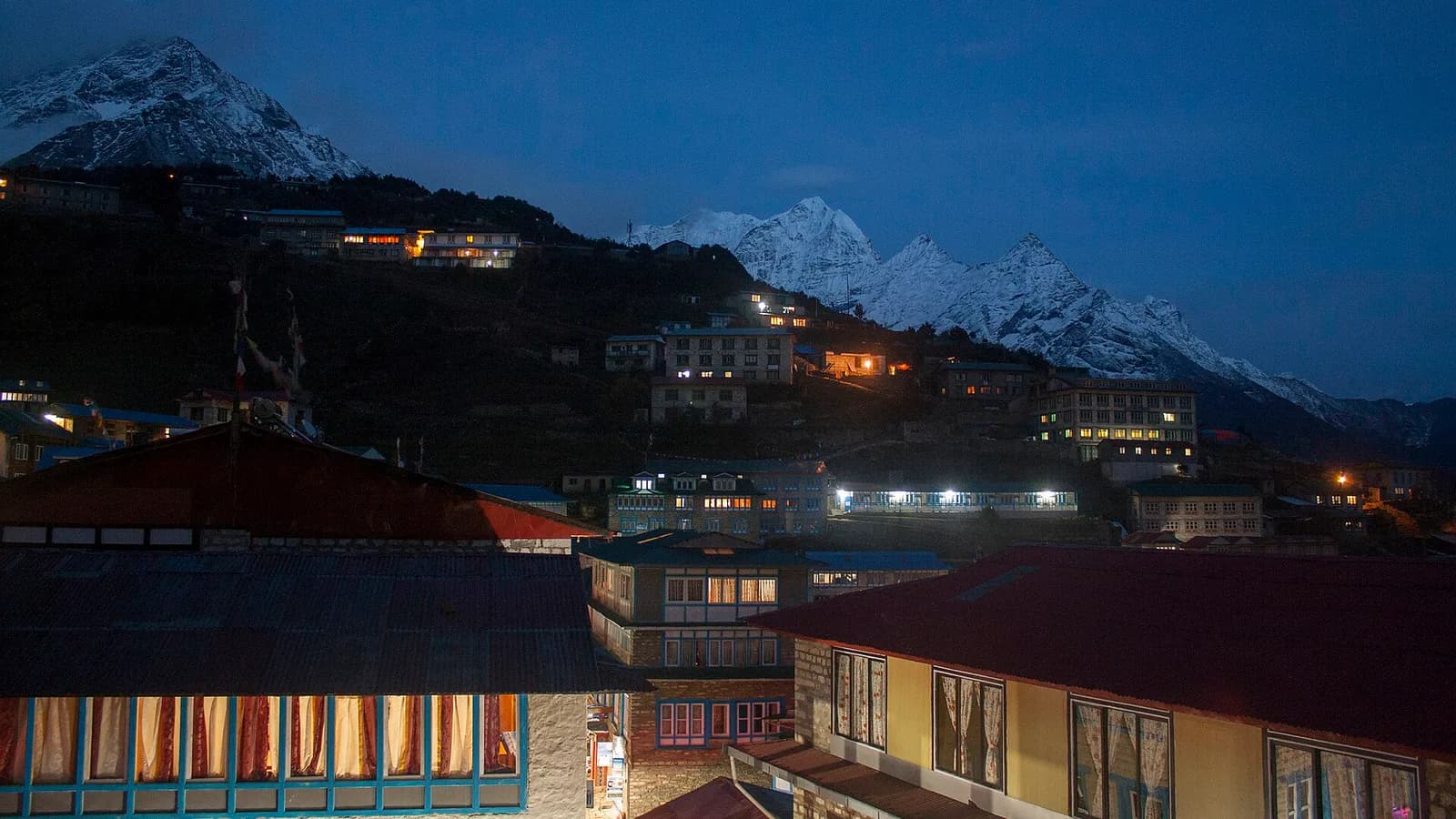 Namche Bazaar lodges at night below snow peaks in the Khumbu