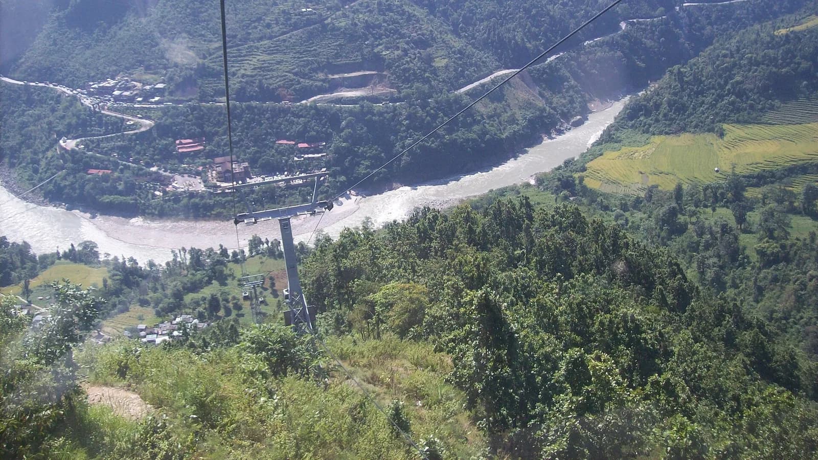 Aerial view of terraced hills and a river valley in rural Nepal, the kind of landscape the Prithvi Highway crosses between Kathmandu and Pokhara