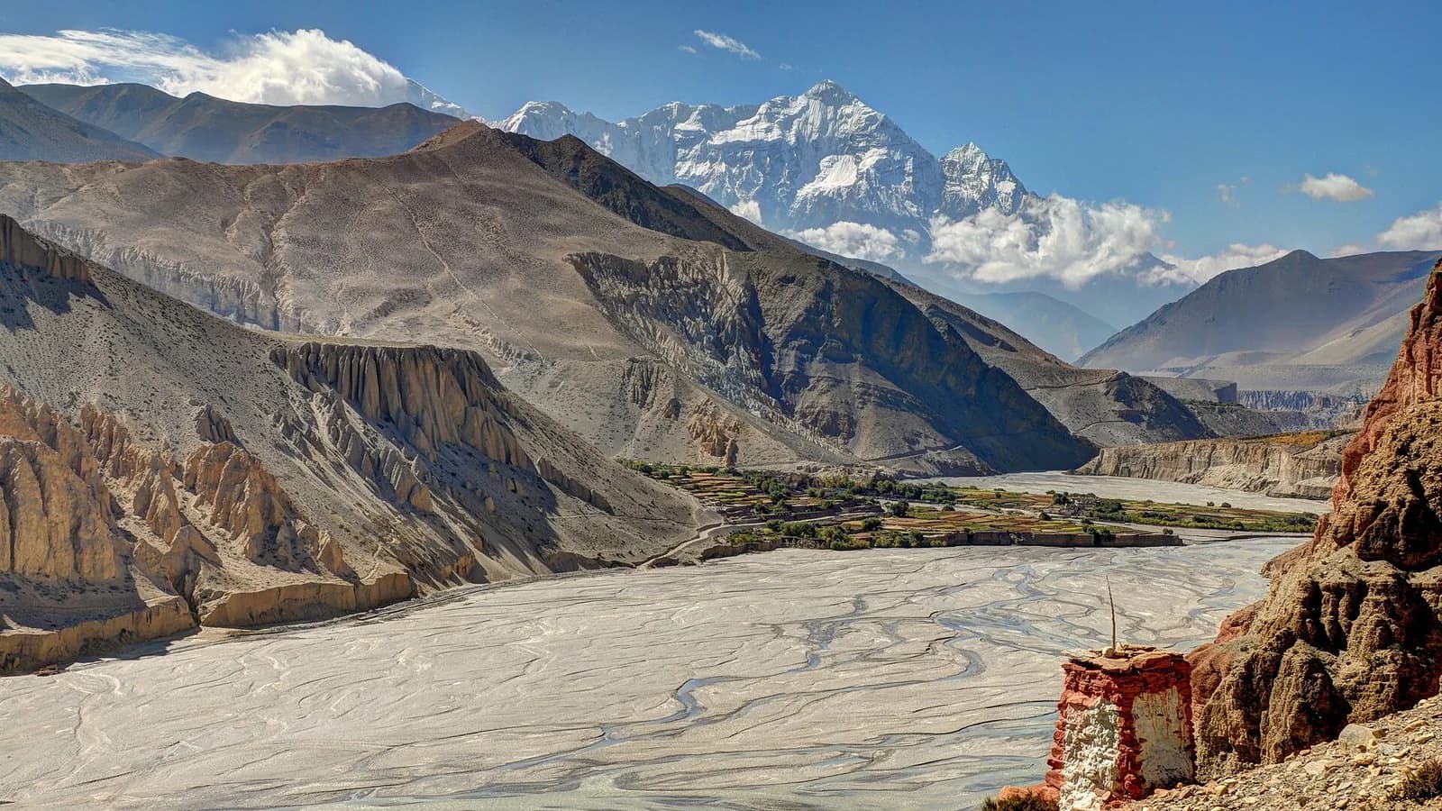 The wide grey gravel riverbed of the Kali Gandaki cutting through the arid cliffs of Upper Mustang