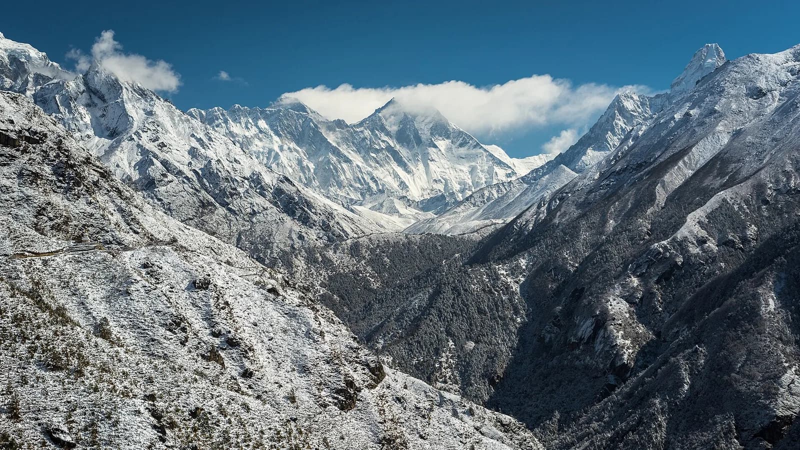 Mount Everest and surrounding Himalayan peaks rising under a clear sky in the Khumbu region of Nepal