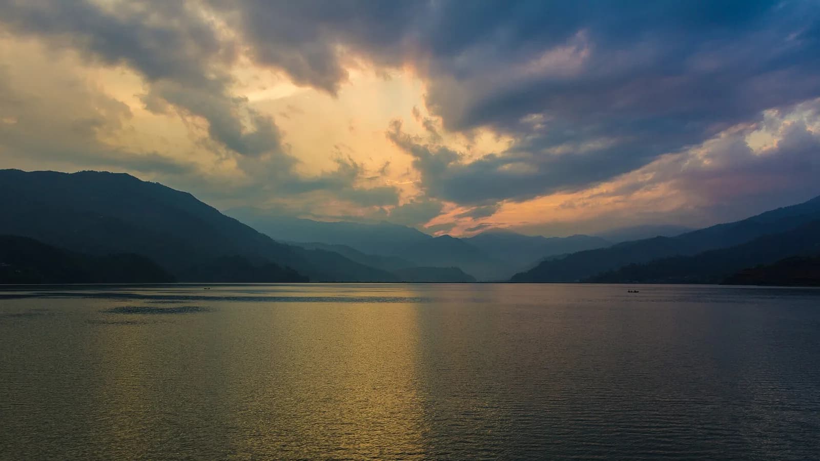 Sunset glowing over the calm water of Phewa Lake in Pokhara