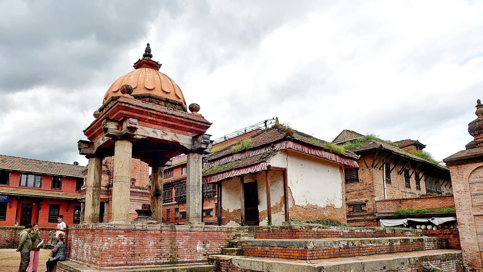 A stone shikhara temple on Bhaktapur Durbar Square in the Kathmandu Valley, with traditional Newar brick architecture around it