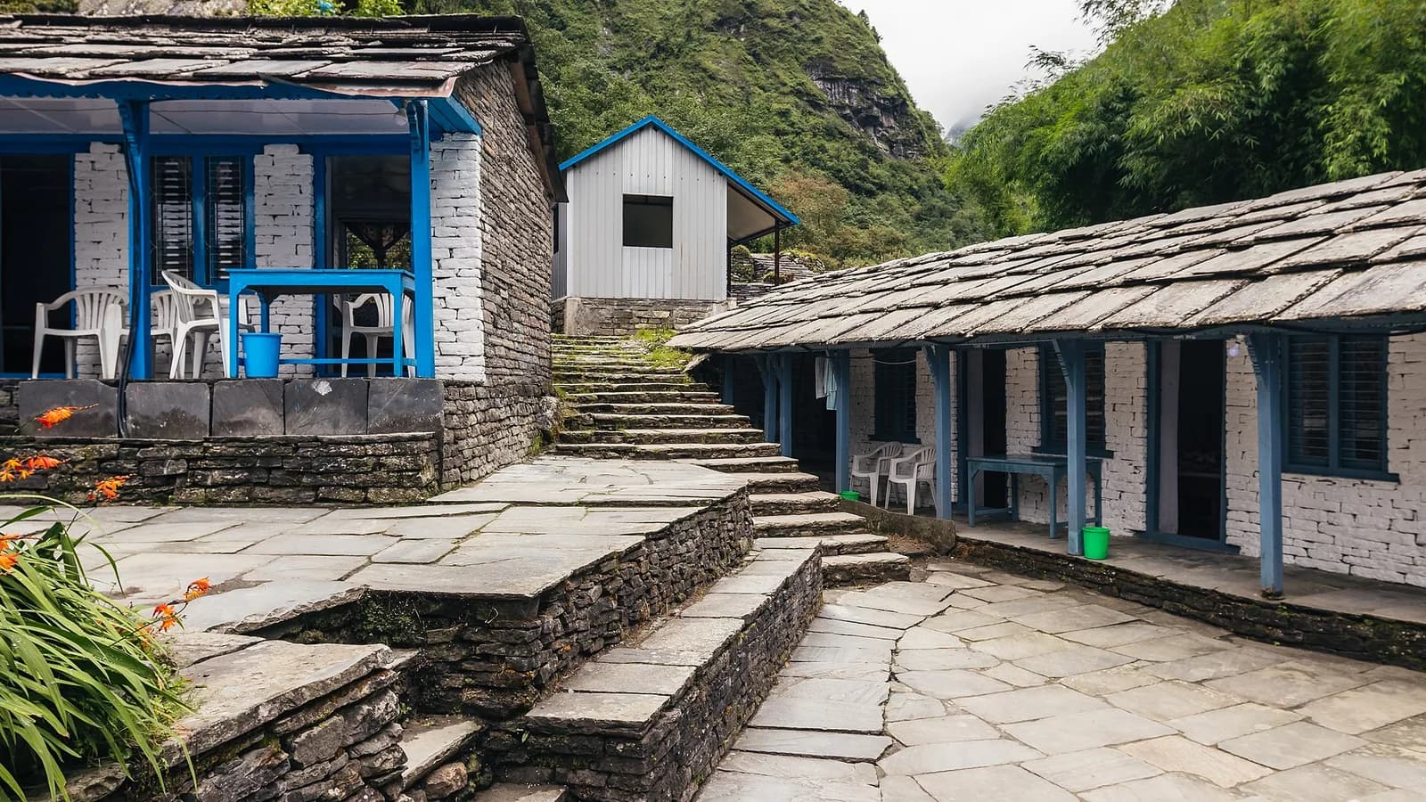 A cluster of stone-and-mud village houses on a high Himalayan ridge in Upper Mustang, Nepal, with bare mountains behind.