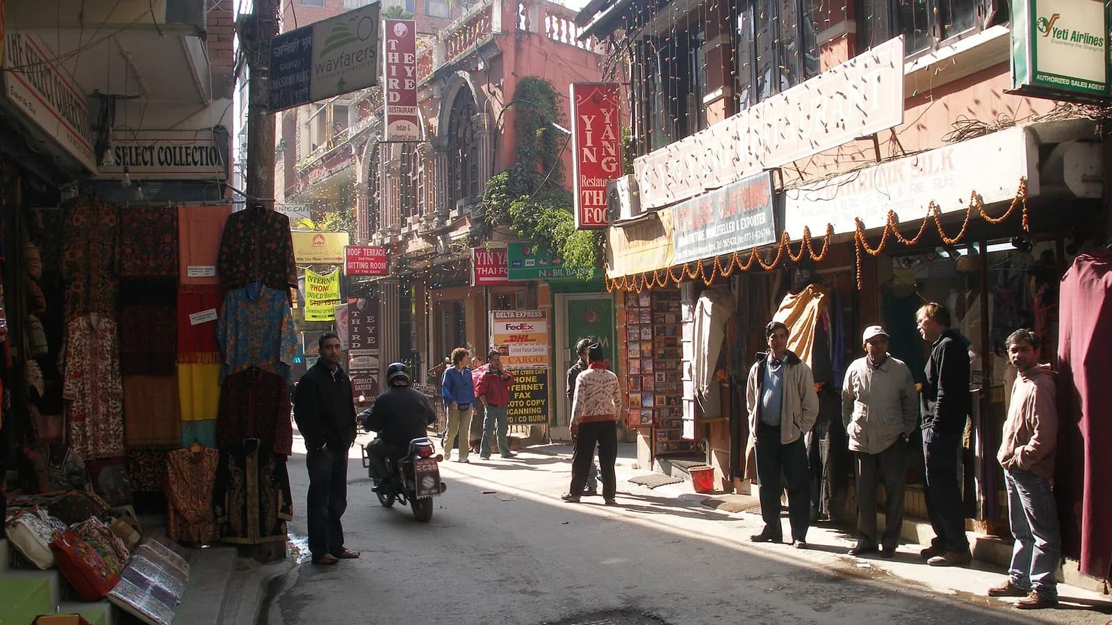 Shop-lined street in Thamel, Kathmandu, busy with market stalls and signage