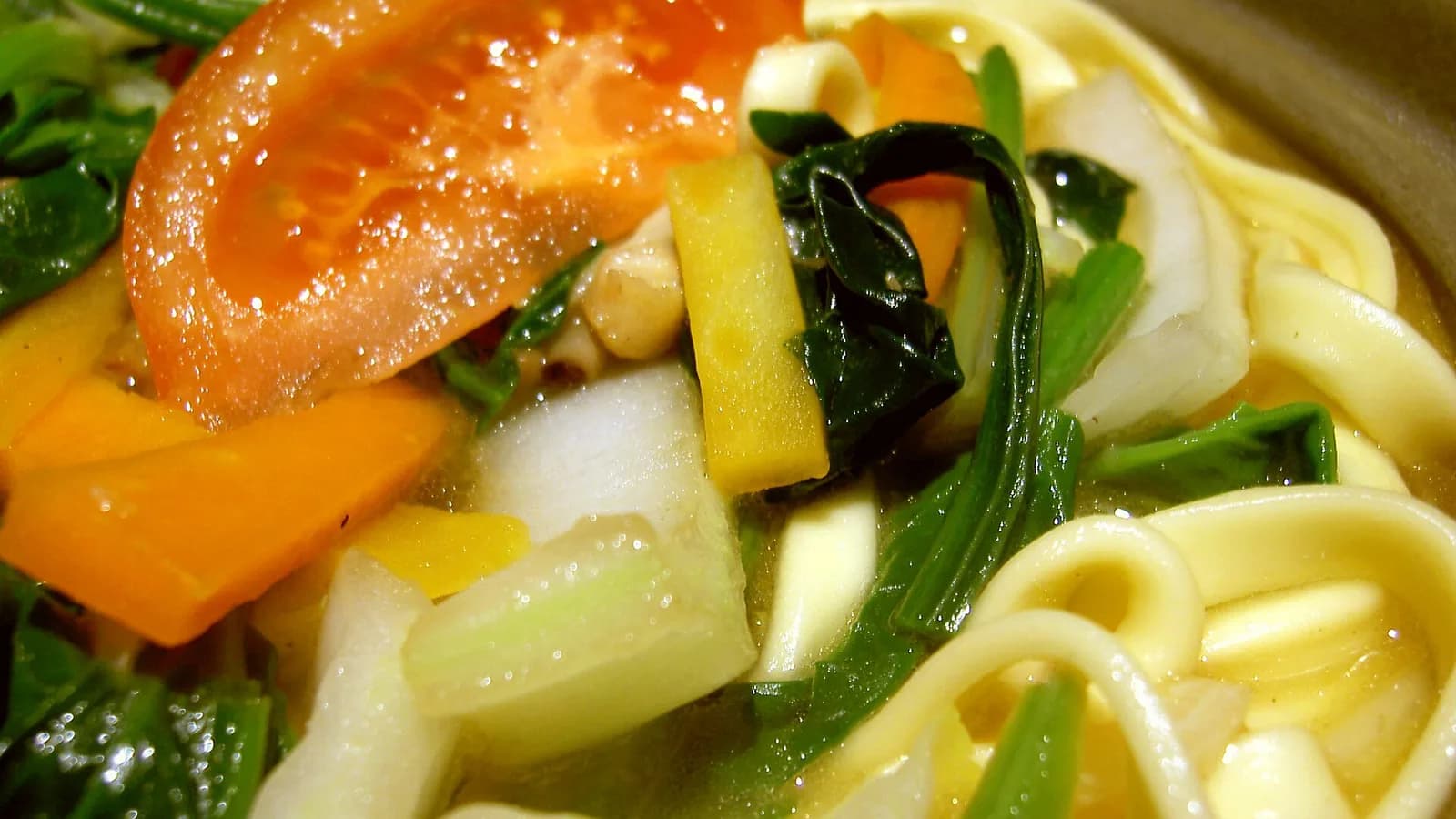 A steaming bowl of thukpa, Himalayan noodle soup with broth, noodles and vegetables