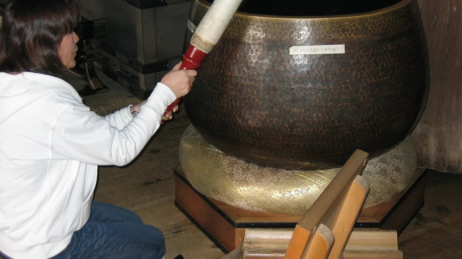 A bronze Himalayan-style singing bowl resting on a cushion, the kind played by striking or circling the rim
