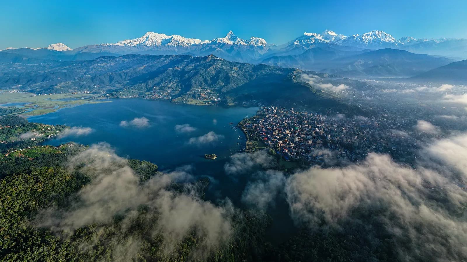 A clear morning view over Pokhara with Phewa Lake and the Annapurna mountains behind the city