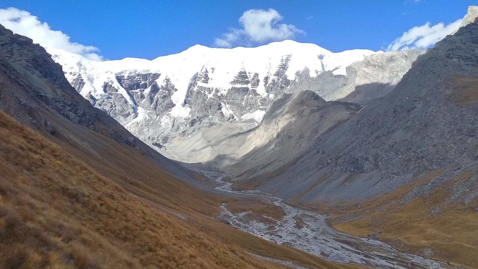 Turquoise Phoksundo Lake ringed by arid ridges and snow peaks in Shey Phoksundo National Park, Dolpa, Nepal
